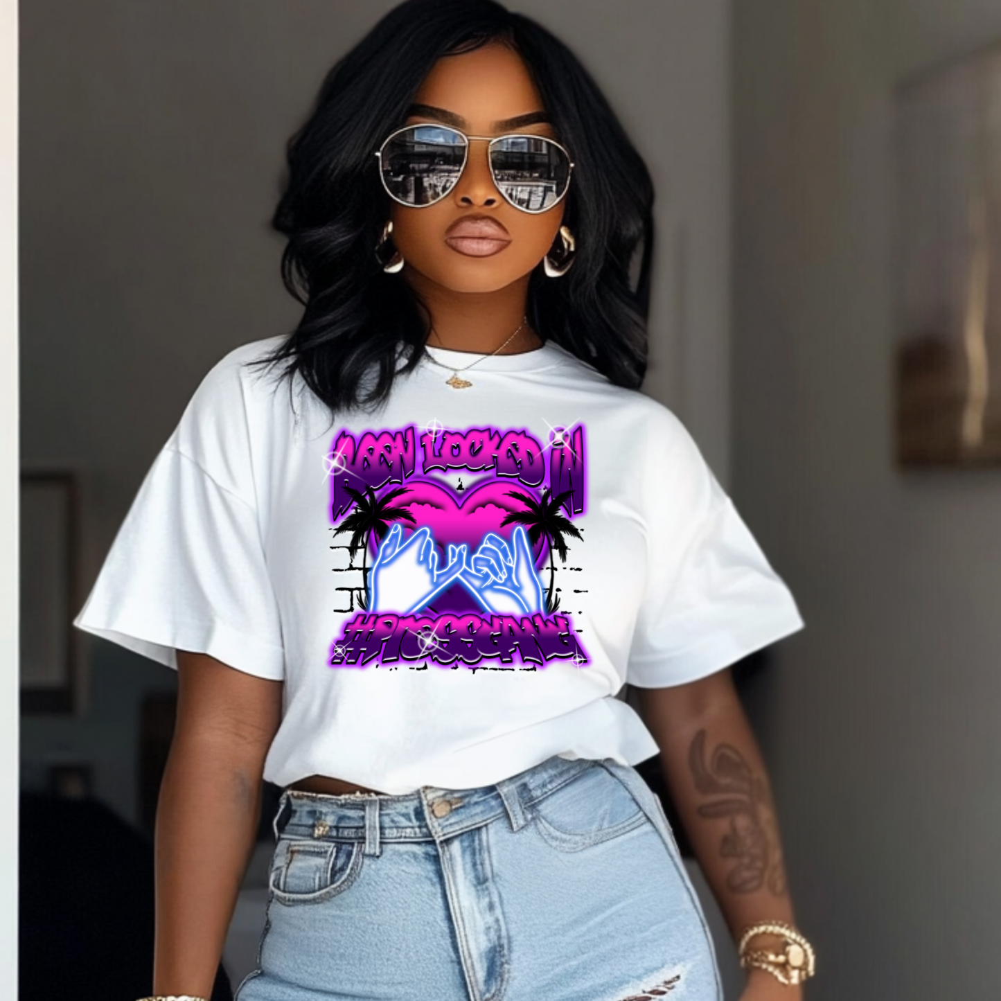 Person wearing a white t-shirt with a colorful graphic design, standing indoors.